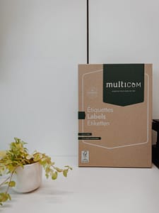 une grande boîte de "Étiquettes" de la marque Multicom est présentée. Une plante similaire à celle de gauche est visible sur la gauche de la boîte.